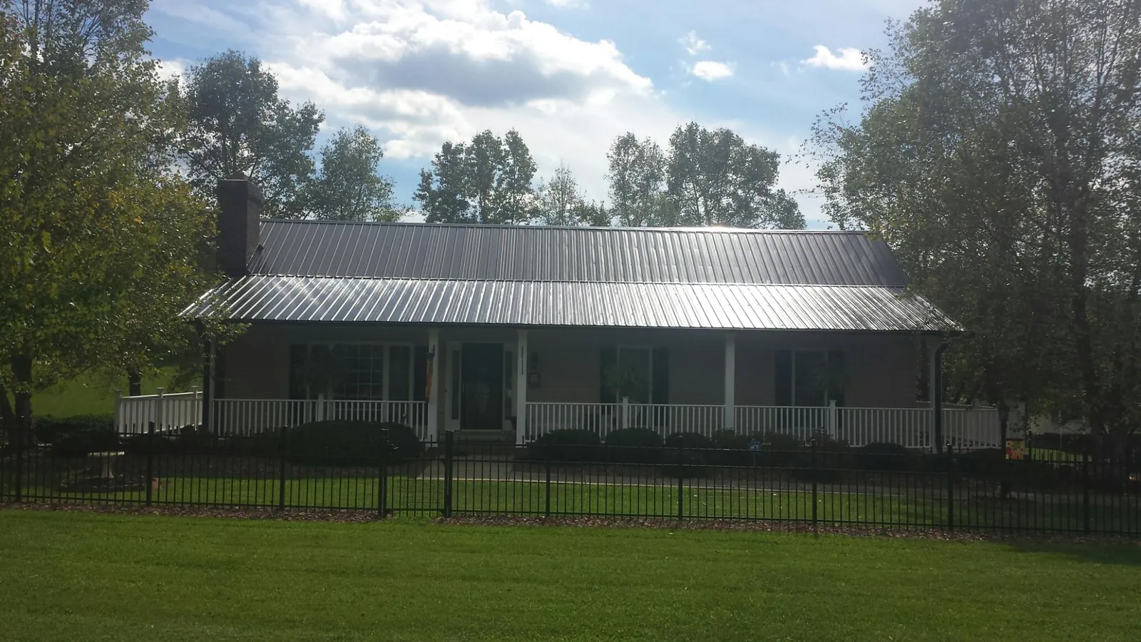 Gray metal roof on a brick ranch with a full width front porch — Gutter Guard Installation work by our crew in Burnsville